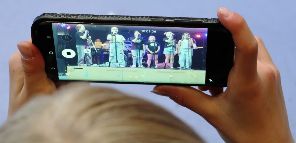 Ein Foto unserer Schülerband wird mit einem Handy aufgenommen.